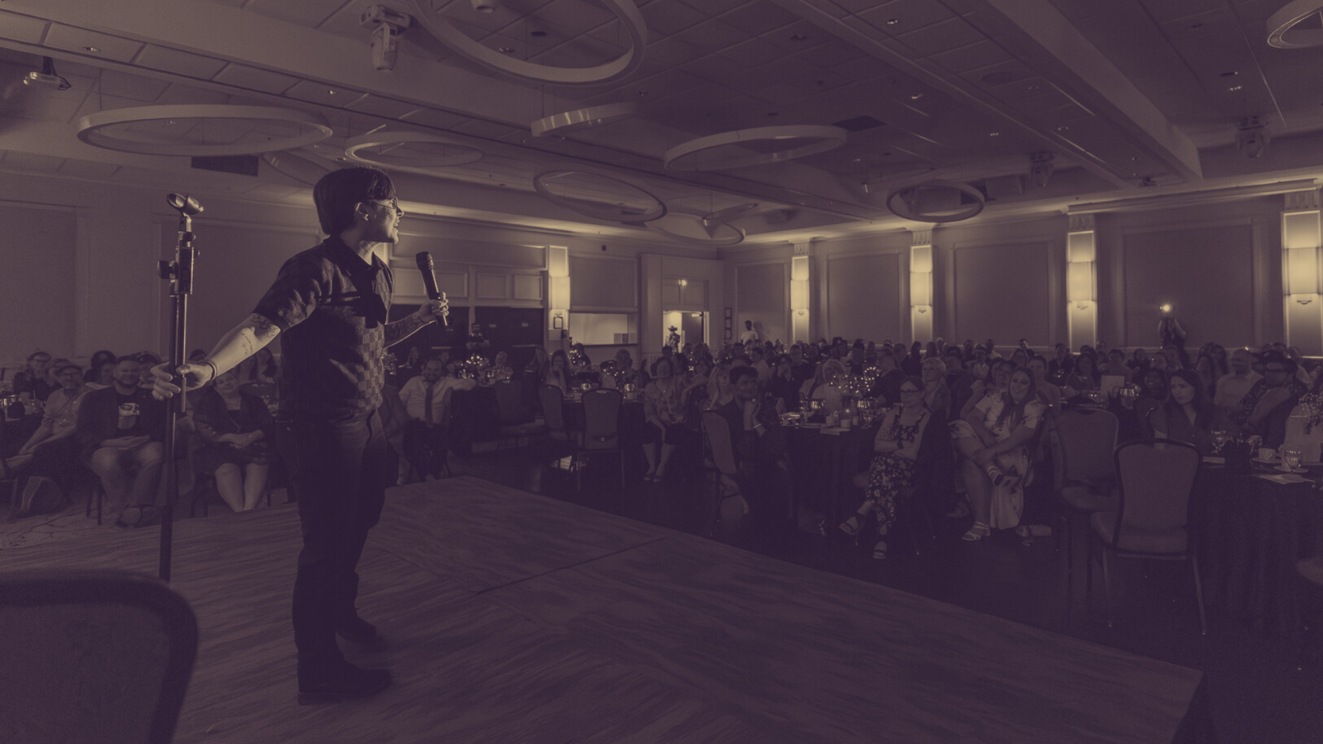 A photo in sepia tones of DeAnne Smith in front of a crowd at the 2025 gala.
